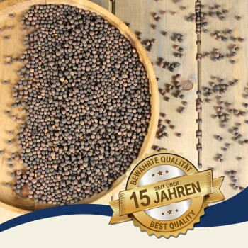 Eine Holzschüssel, gefüllt mit kleinen, dunklen Samen, mit einigen verstreuten Samen. Ein Abzeichen in der Ecke liest 'Best Quality - 15 Jahre' auf Deutsch.
