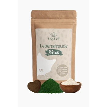 Eine braune Tüte beschriftet mit "HeyFeli Lebensfreude Bites" mit einer Katze, umgeben von grünen und weißen Pulvern und einem herzförmigen Leckerli.