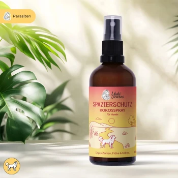 Braune Sprühflasche, beschriftet mit 'spazierschutz kokossspray' mit einem grünen Etikett, das behauptet, vor Zecken, Flöhen und Milben zu schützen.
