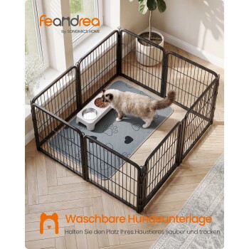 Katze in schwarzem Metalllaufstall auf Pfotenmuster-Matte mit Fressnäpfen; sichtbarer Text 'feandrea' und 'Waschbare Hundeunterlage'