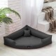 Ein modernes, dreieckiges Haustierbett in Dunkelgrau mit einem kleinen passenden Kissen, platziert in einem hellen Raum mit einer Pflanze und einer gemütlichen Decke.