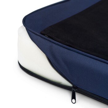 Nahaufnahme eines Haustierbettes mit einem navyblauen Stoffbezug und einem schwarzen Oberteil, das ein weißes Schaumstoffinnere und einen Reißverschluss zeigt.