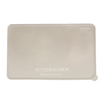 Eine beige Futtermatte für Haustiere mit dem Text "FUTTERSTATION" und "kleckern erlaubt" in Weiß gedruckt, entworfen, um Verschüttungen aufzufangen.