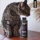 Eine getigerte Katze sitzt neben einer Dose ALPHAZOO Premium Hanföl auf einer Holzoberfläche, mit einem Pfotenabdruckdesign und Text auf Deutsch.