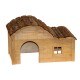 Holzhaustierhaus mit einem gewölbten Rinden-Dach, das einen gewölbten Eingang und ein kleines Fenster an der Seite hat.