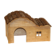 Holzhaustierhaus mit einem gewölbten Rinden-Dach, das einen gewölbten Eingang und ein kleines Fenster an der Seite hat.