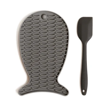 Graue Silikon-Haustierfütterungsmatte in Fischform, mit einer strukturierten Oberfläche, begleitet von einem passenden Spatel.