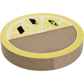 Round corrugated cardboard cat scratcher with yellow lemon-slice top, smile cutout and green toy peeking through holes.