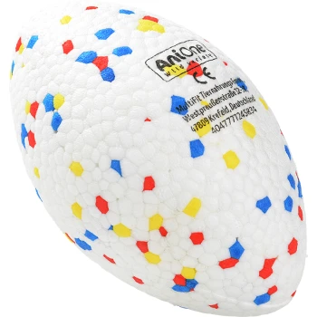 Ein farbenfrohes Hundespielzeug in Form eines Rugbyballs, mit einer weißen Oberfläche und roten, blauen und gelben Sprenkeln, sowie einem Etikett mit Markeninformationen.
