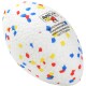 Ein farbenfrohes Hundespielzeug in Form eines Rugbyballs, mit einer weißen Oberfläche und roten, blauen und gelben Sprenkeln, sowie einem Etikett mit Markeninformationen.