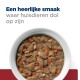 Eine weiße Schüssel mit feuchtem Haustierfutter mit Fleisch, Karotten und Reis, garniert mit dem Text "Een heerlijke smaak waar huisdieren dol op zijn."