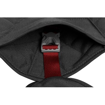 Nahaufnahme eines schwarzen Haustiergeschirrs, das eine graue Schnalle und einen roten Riemen zeigt und das Innendesign des Geschirrs hervorhebt.