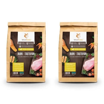 Zwei Beutel Wildfang-Hundefutter, beschriftet mit "Huhn-Truthahn", mit Zutaten wie Lachs, Süßkartoffeln und Karotten.