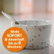 Eine weiße Schüssel voller Ameisen, begleitet von einem Löffel, mit einem orangefarbenen runden Etikett, das besagt: "Wirkt SOFORT & dauerhaft bis zu 6 Wochen!"