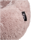 Eine Nahaufnahme eines weichen, rosa Haustierbettes mit flauschiger Textur, das ein schwarzes Etikett mit der Aufschrift "Pawtastic" trägt.