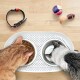 Oranger getigerter frisst Trockenfutter und grau-weiße Katze trinkt aus Metallschalen auf weißer Matte; Halsband und Spielzeug auf Holzboden