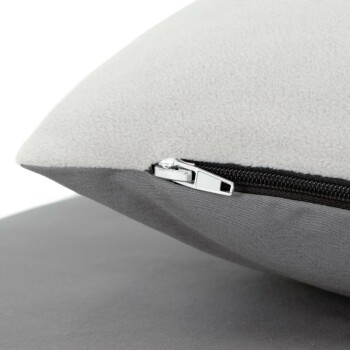 Nahaufnahme einer Ecke eines Haustierbettes mit grauem Stoff und Reißverschluss, die seine weiche Textur und das strapazierfähige Design zeigt.