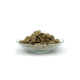 Eine Glasschüssel gefüllt mit kleinen, braunen Haustierfutterpellets, die eine Vielzahl von Formen und Größen vor einem weißen Hintergrund zeigen.