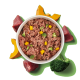 Schüssel mit rohem Tierfutter mit Fleischstücken, Brokkoli und Kürbis auf grünem Hintergrund.
