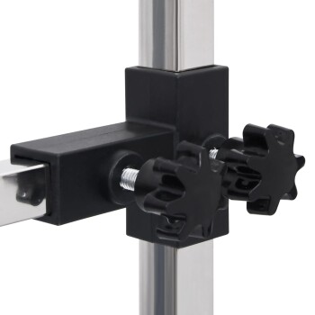 Nahaufnahme eines schwarzen Kunststoffverbinders mit zwei sternförmigen Knöpfen, die Metallstangen in einem Haustiergeschäft-Display-Setup verbinden.