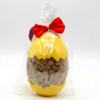 Gelber, eiförmiger Behälter gefüllt mit braunen Haustierleckerlis, in Klarsichtfolie mit roter Schleife oben verpackt.