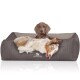 Ein gemütliches Hundebett in Grau mit einem Logo, das "KNUFFELWUFFF" liest, mit einem entspannten Australian Shepherd und einem braunen Hund, der bequem liegt.