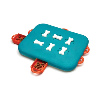 Interaktives Hundepuzzle-Spielzeug mit einer türkisfarbenen Basis, mit sechs weißen, knochenförmigen Teilen und zwei roten Seitenfächern, die mit Futter gefüllt sind.
