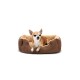 Ein kleiner braun-weißer Chihuahua sitzt bequem in einem plüschigen, braunen Hundebett mit einem weichen, beigen Innenraum.