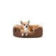 Ein kleiner braun-weißer Chihuahua sitzt bequem in einem plüschigen, braunen Hundebett mit einem weichen, beigen Innenraum.