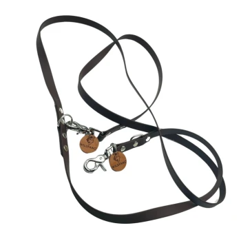 Braune doppelte Hundeleine mit Metallclips und Holzanhängern, beschriftet mit "WILDFANG", in einer verworrenen Position auf einem weißen Hintergrund angeordnet.