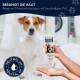 Eine Hand hält eine Hundeshampoo-Flasche mit der Aufschrift "Beruhigt die Haut" und "Repariert Mikroverletzungen" sowie einem Logo für "Neutraler pH".