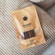 Matatabi-Zahnpflege-Sticks für Katzen in einer braunen Papiertüte, mit sechs Sticks, die neben der Verpackung angezeigt werden.
