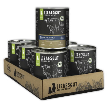 Packung Liebesgut Bio-Nassfutterdosen in Kartonschale, schwarze Etiketten mit Kuhzeichnung und Schriftzug 'LIEBESGUT'.