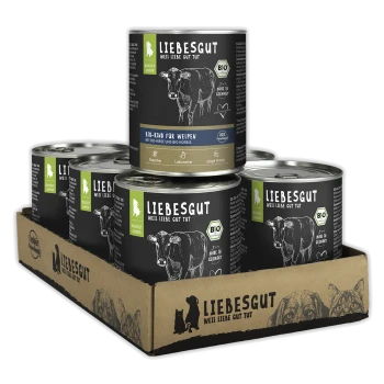 Packung Liebesgut Bio-Nassfutterdosen in Kartonschale, schwarze Etiketten mit Kuhzeichnung und Schriftzug 'LIEBESGUT'.