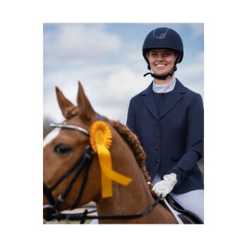 Ein Reiter in einer marineblauen Reitjacke und einem Helm sitzt auf einem braunen Pferd, das mit einem gelben Band geschmückt ist, und zeigt einen wettbewerbsfähigen Geist.