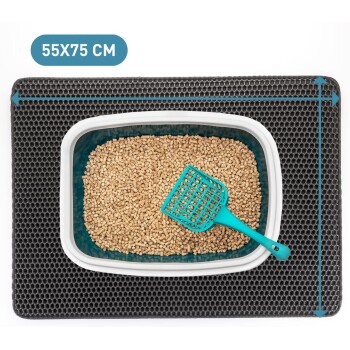 Eine Katzenstreu-Box gefüllt mit Pellets, begleitet von einem türkisfarbenen Schaufel, auf einer strukturierten schwarzen Matte platziert. Abmessungen: 55x75 cm.