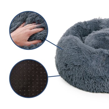 Nahaufnahme eines weichen, grauen Haustierbettes mit einer Hand, die in den plüschigen Stoff drückt, und einer detaillierten Ansicht des rutschfesten Bodens.