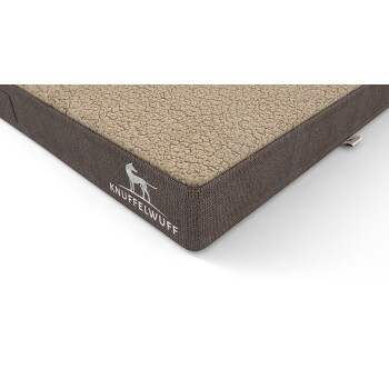 Ein gemütliches Hundebett mit einer plüschigen beige Oberseite und einer dunkelgrauen strukturierten Seite, mit dem Markennamen "KNUFFELWUFF" und einer Hundesilhouette.