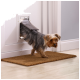 Een kleine Yorkshire Terrier komt tevoorschijn uit een huisdierdeur, met zijn voorpoten op een bruine deurmat. De deur is wit met een flap.