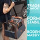 Eine tätowierte Person trägt eine robuste Tragetasche für Haustiere mit Netzpaneelen, beschriftet mit "TRAGE KOMFORT", "FORM STABIL" und "BODEN MASSIV."