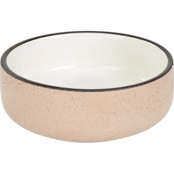 Eine runde Futterschüssel für Haustiere mit einer strukturierten pinken Außenseite und einer glatten weißen Innenseite, mit einem dunklen Rand.