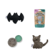 Eine Sammlung von Haustierspielzeugen: eine schwarze Fledermaus, graue und türkisfarbene Filzkugeln, ein graues Katzenspielzeug und ein Paket "Vitamin-Milchshake" für Katzen.