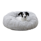 Ein gemütliches, flauschiges graues Hundebett mit einem weißen Hund, der darin ruht, und das seine weiche Textur und runde Form zeigt.