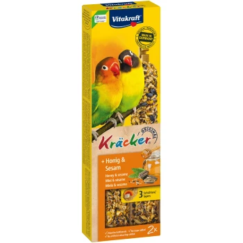 Vitakraft Kräcker Vogelsnackbox mit zwei bunten Liebesvögeln, mit Honig- und Sesamgeschmack, die natürliche Zutaten und Vitamine hervorhebt.