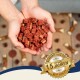 Hände halten einen Stapel kleiner, roter Hundeleckerlis mit einem goldenen Abzeichen, das in der Ecke "Best Quality seit über 15 Jahren" besagt.