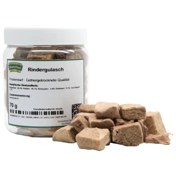 Gefriergetrocknete Rindfleischwürfel in einem klaren Glas mit der Aufschrift "Rindergulasch" von Masterfeed, mit Nährwertanalyse und Zutaten aufgelistet.