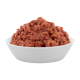 Eine weiße Schüssel gefüllt mit einem Haufen rohem Haustierfutter, das eine klumpige, fleischige Textur in verschiedenen Rosa- und Brauntönen aufweist.