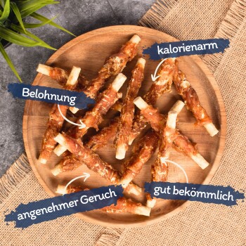 Ein Holzbrett mit stickförmigen Hundeleckerlis, die in Fleisch eingewickelt sind, beschriftet mit "Belohnung", "kalorienarm", "angenehmer Geruch" und "leicht verdaulich."