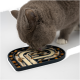 Eine graue Katze leckt eine Puzzle-Futtermatte, die mit cremigem Futter und trockenem Futter gefüllt ist, um die Haustiere während der Fütterung zu beschäftigen.