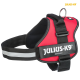 Rotes Julius-K9 Hundegeschirr mit schwarzen Riemen, ausgestattet mit einem reflektierenden Streifen und einem Metall-D-Ring zur Leinenbefestigung.
